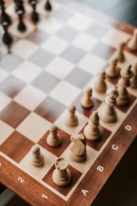 Close-up of a wooden chessboard showing a strategic game setup.